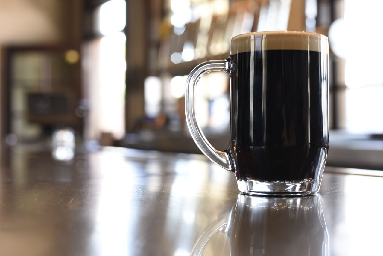 A glass of dark session beer with a thick tan foam head, showing that low-ABV beers can have rich appearance