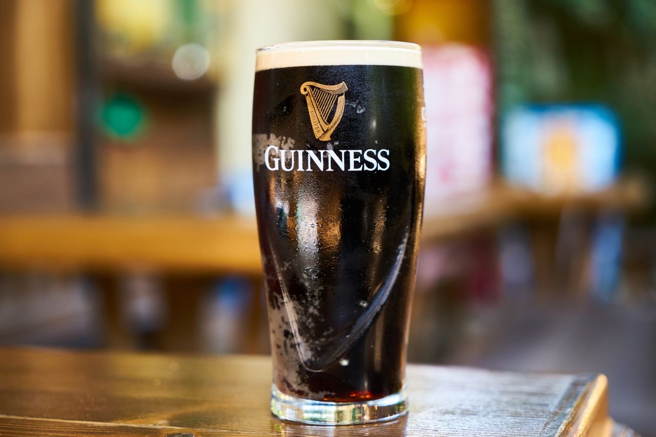 A clear golden lager in a tall glass with condensation on the outside