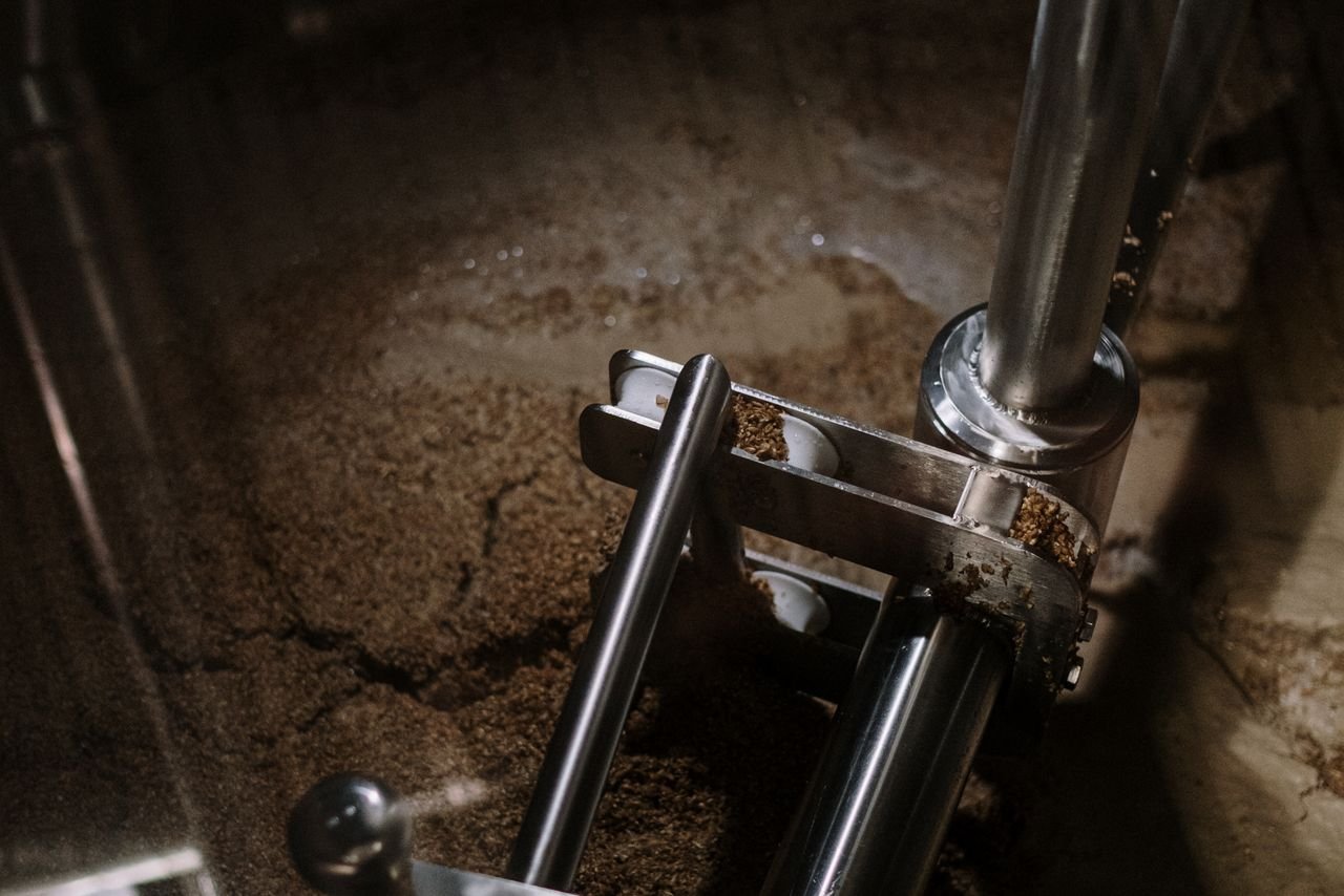 Homebrewing equipment including a fermenter and hop additions on a brew bench
